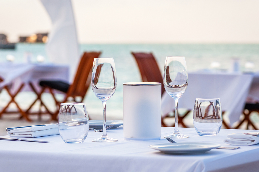 Specialized Business Insurance - Fine Dining Restaurant Table Set Up for Dinner on the Beach at Dusk